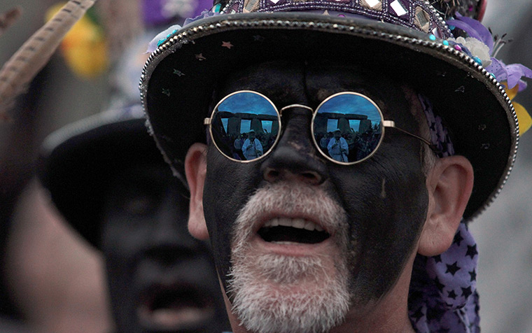 summer solstice: Stonehenge is relected in the glasses of a morris dancer