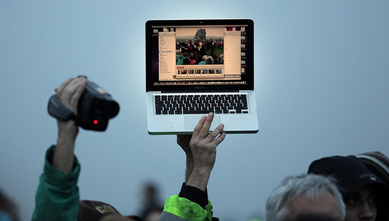 summer solstice: Solstice celebrations are recorded on a laptop and a video camera