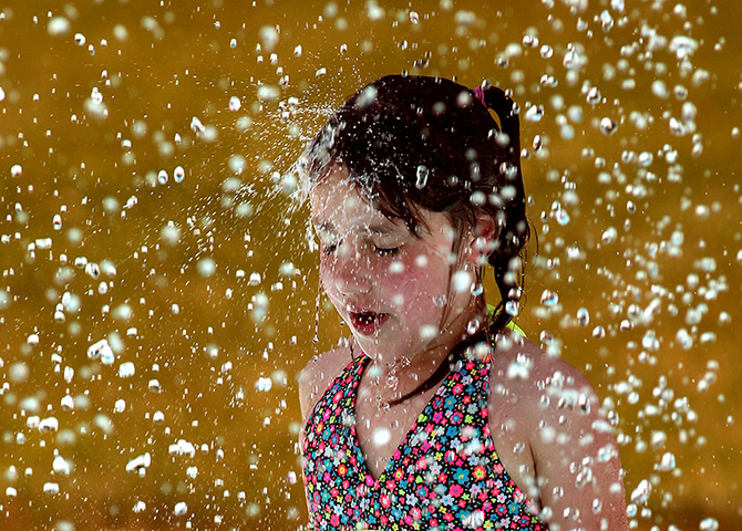 24 hours in pictures: a seven-year-old cools off at a pool in New Jersey