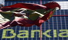 A Spanish flag flutters in front of the headquarters of Bankia