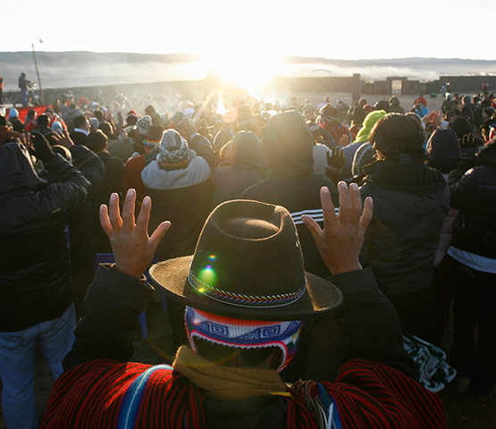 24 hours in pictures: People raise their hands to receive the sun