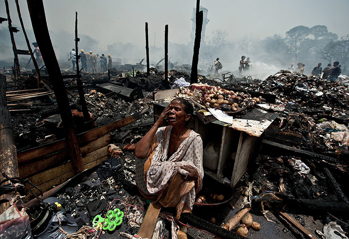 Picture desk live: A resident criesafter her shanty house burnt down