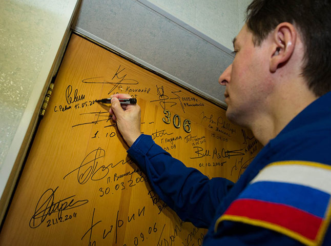 Month in Space: Expedition 31 Flight Engineer Sergei Revin performs tradition of signing 