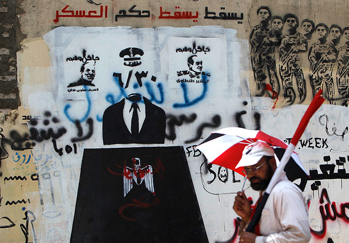 Egypt elections: A man walks past a wall sprayed with graffiti near Tahrir square