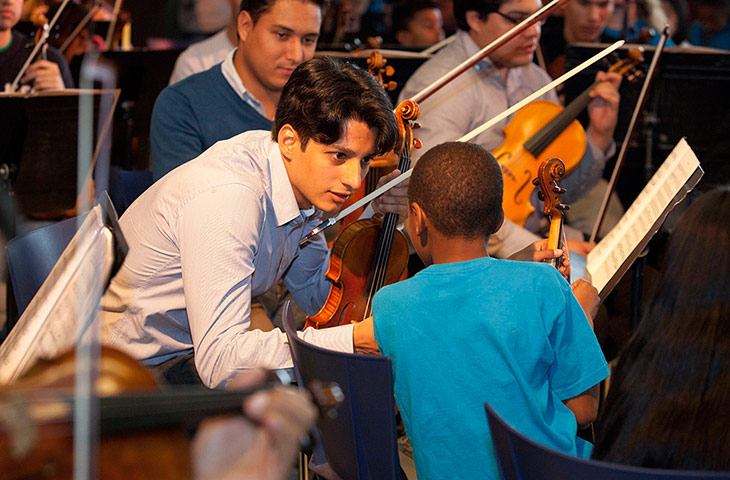 Southbank: A violinist from the Simon Bolivar orchestra with a young musician