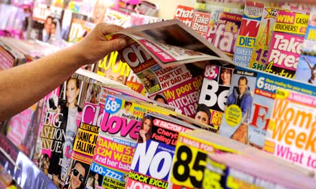 A person removes a magazine from a magazine stand
