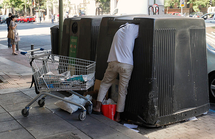 Picture desk live: A man collects paper from a paper container in Madrid
