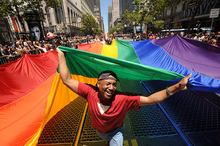 Gay pride week: San Francisco, US: Mark Wilson carries a rainbow flag