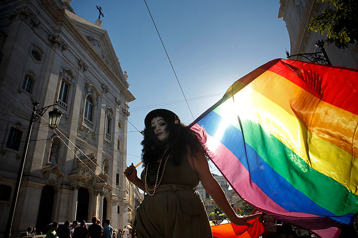 Gay pride week: Lisbon, Portugal: A reveler walks past a church during the parade