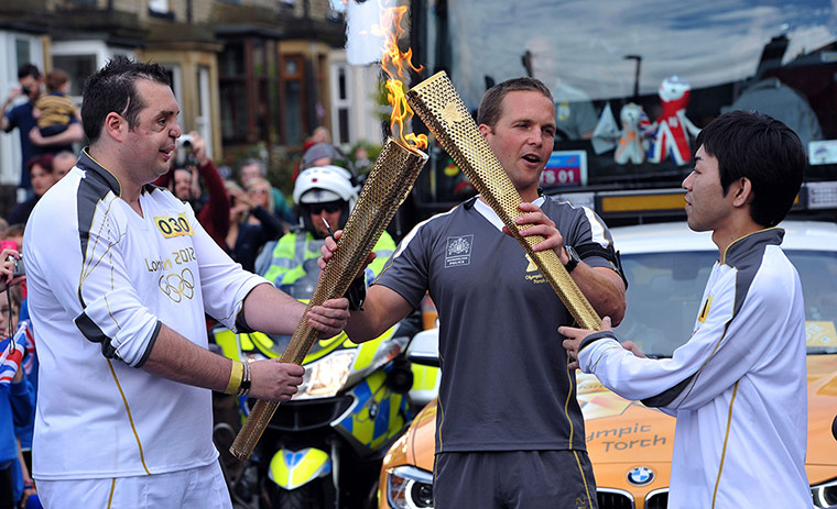 Olympic torch relay: Sadaharu Mishina, right, from Japan, receives the flame in Morley