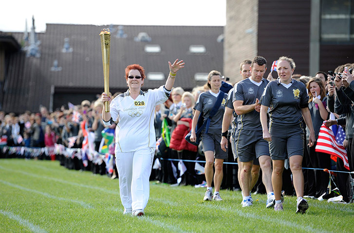 Olympic torch relay: Teresa Loney takes the torch around the playing field of Morley High School