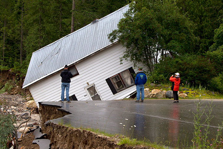 Picture Desk Live: People watch as a house comes off its foundations during floods