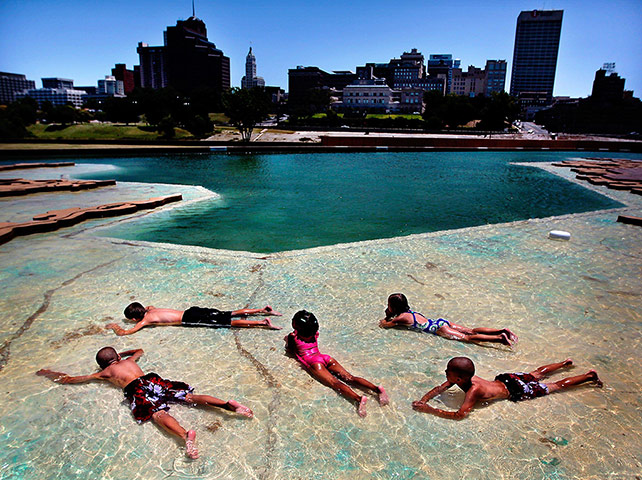 Picture desk live: Children lie in the shallows at the Mud Island River Park in Memphis