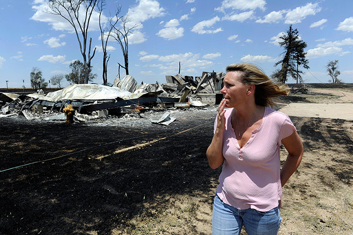 Picture desk live: A woman surveys a house burned to the ground in Woodrow, Colorado