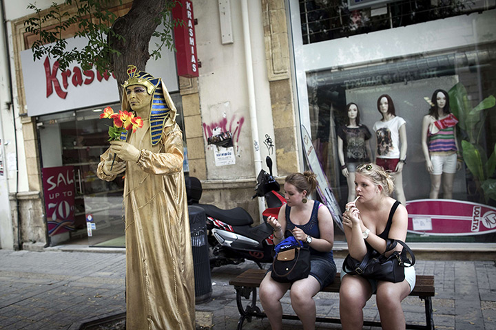 24 hours in pictures: Women sit on a bench near a human statue in Ledra street, Cyprus