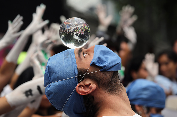 24 hours in pictures: A student protester looks into a crystal ball during demonstration, Mexico