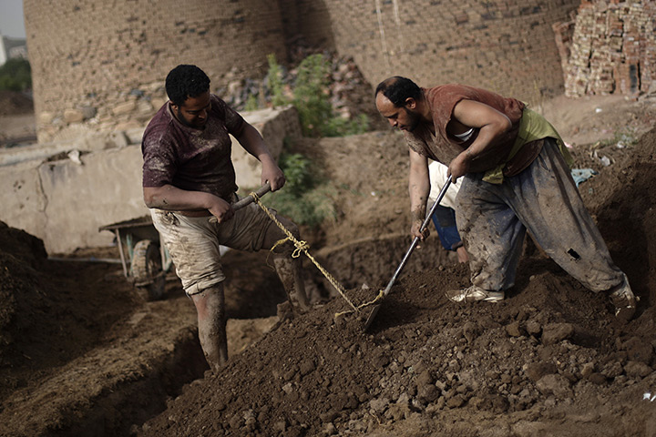 24 hours in pictures: Yemeni labourers manually mix soil at a traditional brick factory