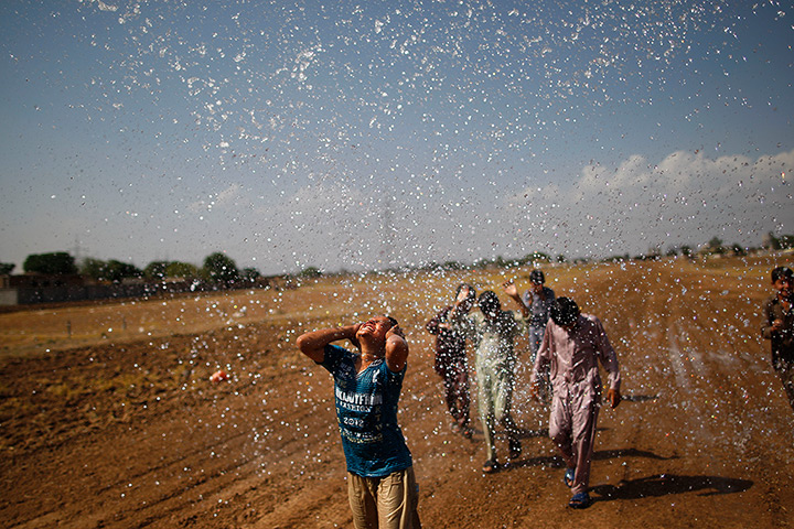 24 hours in pictures: Pakistani boys cool off, under water splashed from a water tanker