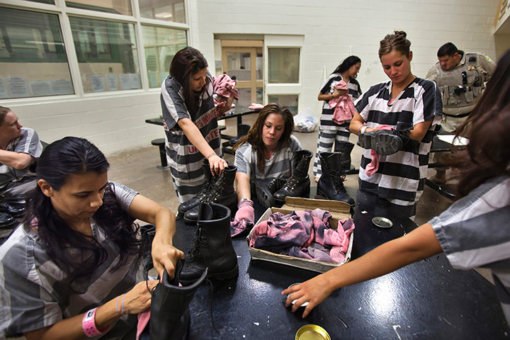 All-female chain gang: Inmates clean the dust off their boots after a day of working in the desert