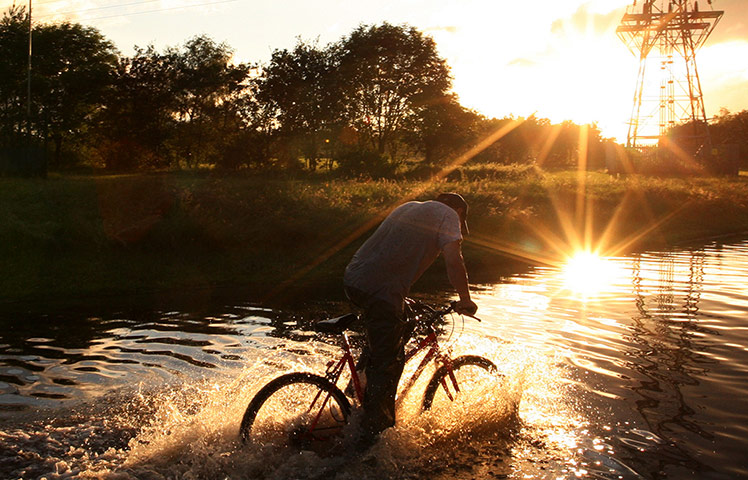 UK Flooding: Hebburn, Tyne and Wear: A man cycles through floodwater on Thursday evening