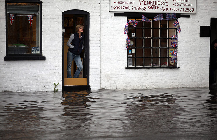 UK Flooding: Penkridge, Staffordshire: Shop workers look out at the flash flooding