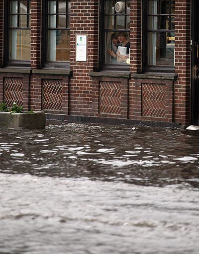 UK Flooding: Penkridge, Staffordshire: Bank workers look out on a rising flash flood