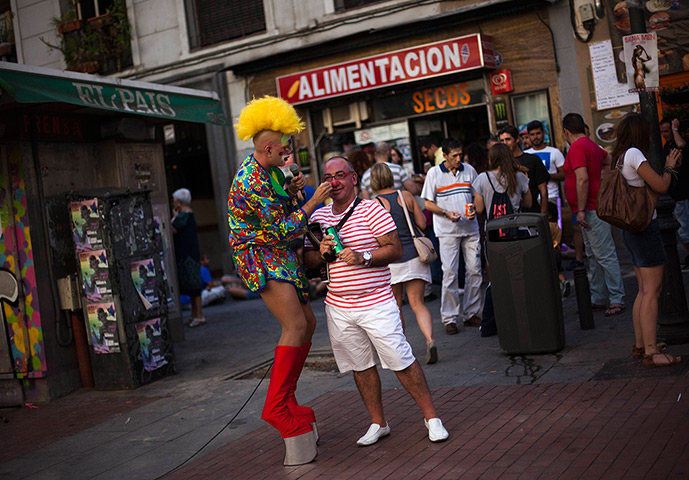 24 hours in pictures: A performer paints a red nose on a passer-by