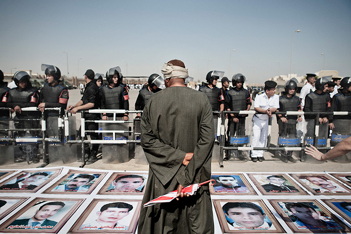 Mubarak trial: Anti Mubarak demonstrator stands in front of images of martyrs