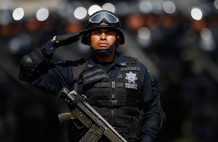 24 hours: A federal police officer salutes during a ceremony marking Police Day