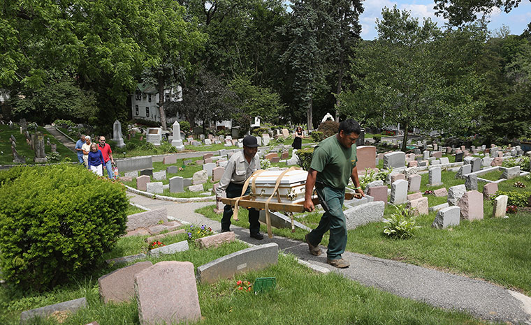 24 hours: New York, US:  Graveyard workers carry a casket containing a pet dog
