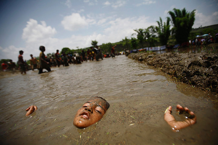 24 Hours: A boy lies in mud while celebrating Asar Pandhra festival in Pokhara valley