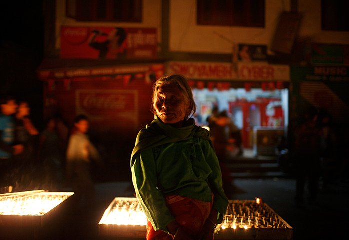 24 hours: Kathmandu, Nepal: A vendor selling butter lamps waits for customers