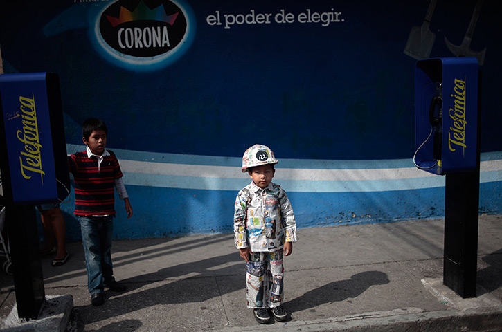 24 hours in pictures: A boy wears an outfit made of newspaper for World Environment Day