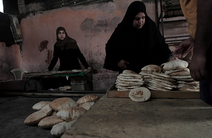 Gaza life: A woman buys freshly baked pita bread