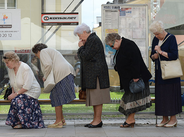 Picture Desk Live: Residents pray at a bus station during the Corpus Christie parade