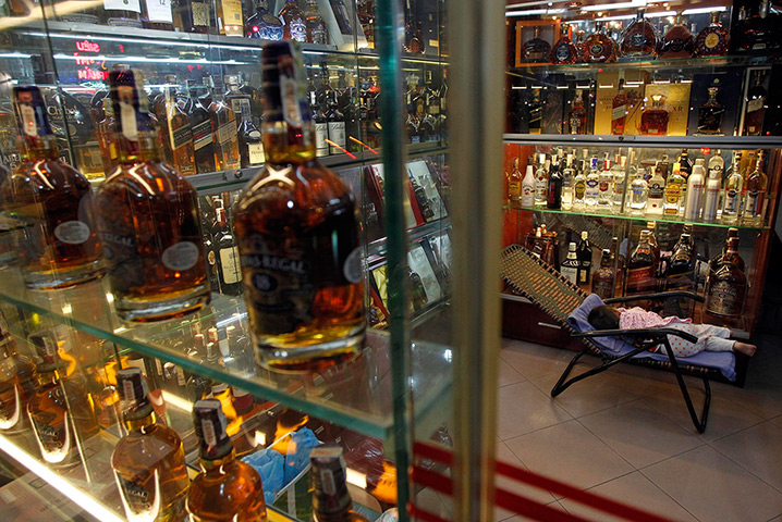 Week in Business: A child sleeps at a shop selling whisky in Hanoi