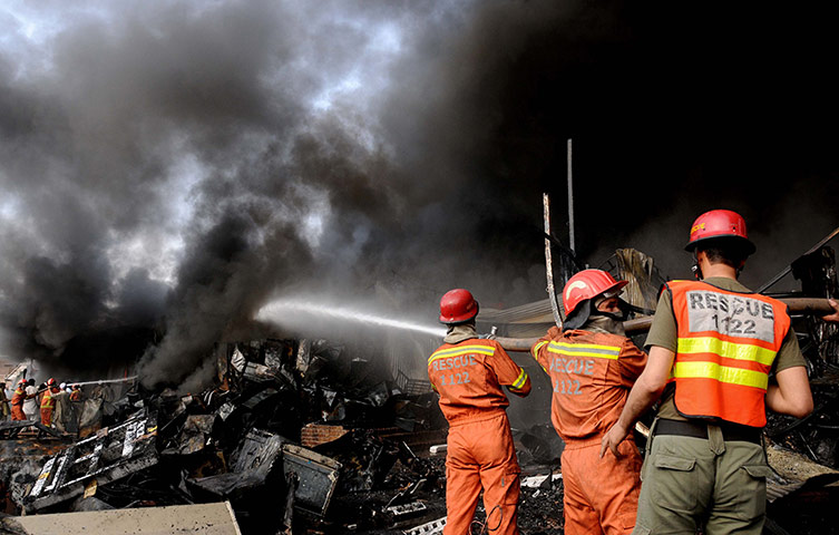 24 Hours: Peshawar, Pakistan: Firefighters try to control a huge fire at a market