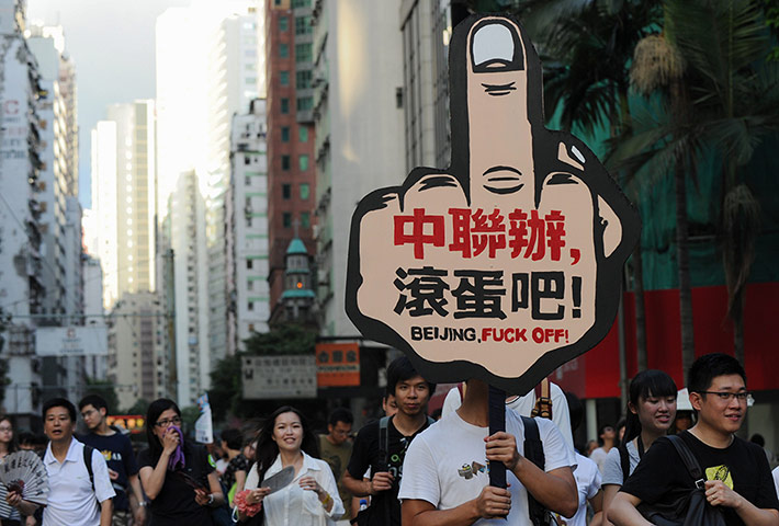 Hong Kong demonstrations: A man carries a placard saying 'Beijing liason office go to hell'