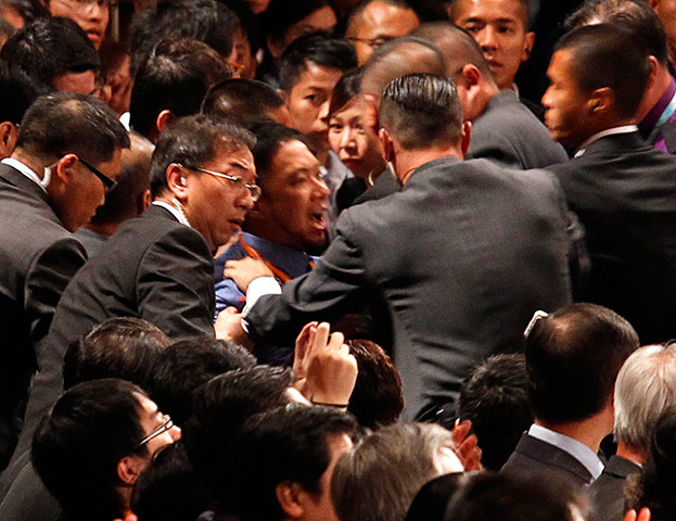Hong Kong demonstrations: A protester is restrained as he chants slogans at president Hu Jintao