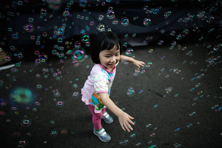 24 hours in pictures: A girl plays with bubbles Hong Kong