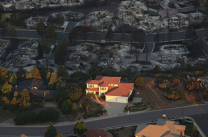 24 hours in pictures: Destroyed homes sit beside a home left untouched by fire