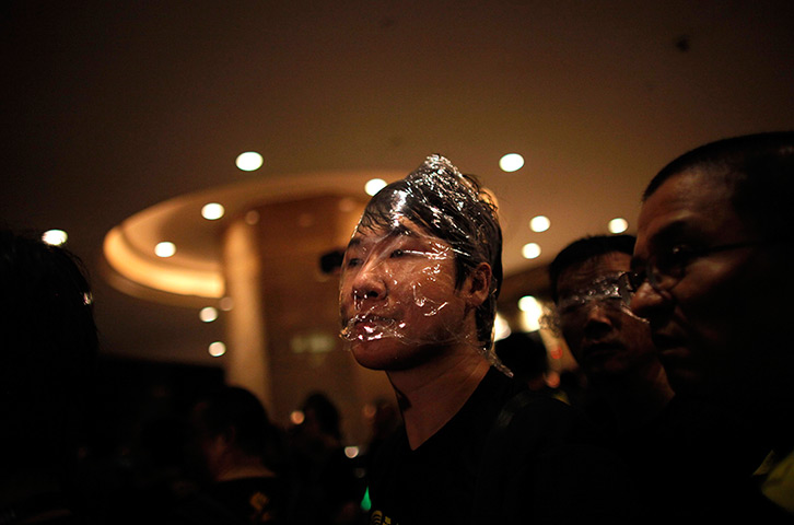 24 hours in pictures: A pro-democracy demonstrator covers his face with plastic wrap, Hong Kong