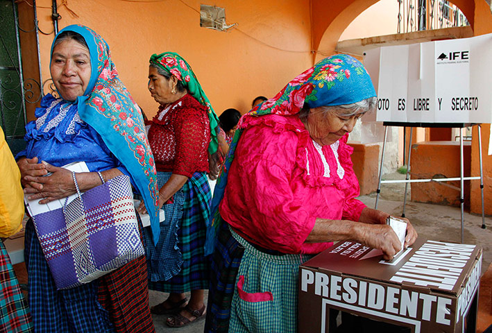 Mexico election: San Bartolome Quialana, Oaxaca: A woman casts her vote at a polling station