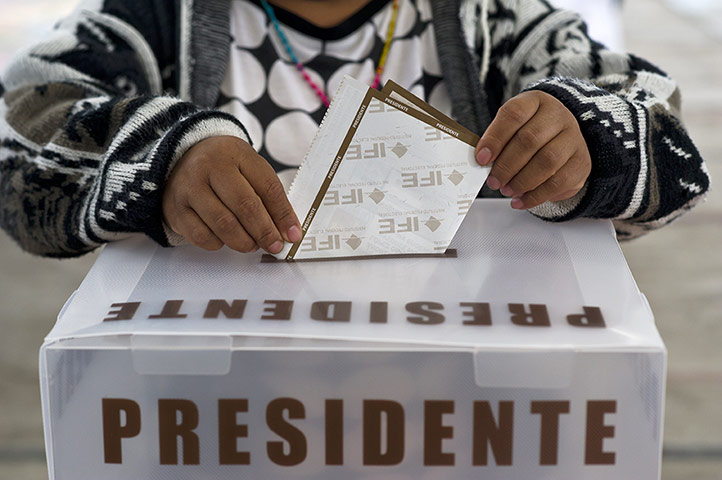 Mexico election: San Lorenzo Tlacoyucan, Mexico City: A woman casts her vote at a school