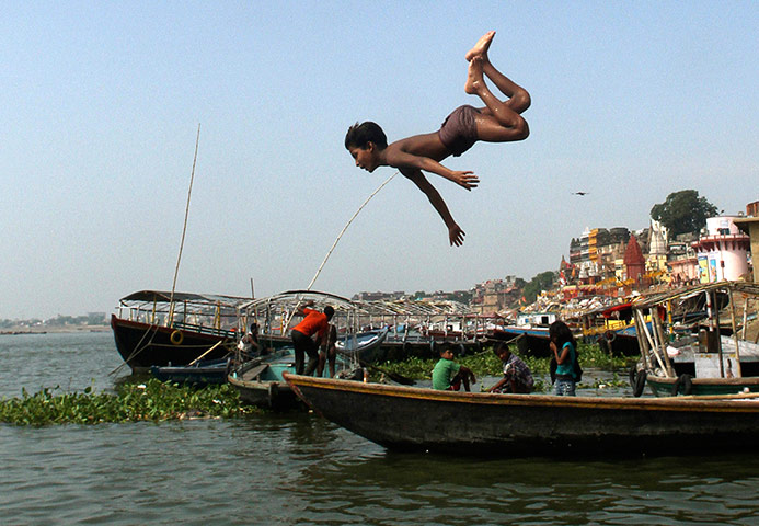 Picture desk live: A child dives into the River Ganges in Varanasi, India