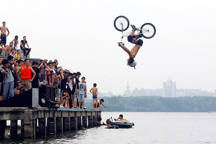 Picture desk live: A biker jumps in to a lake in Wuhan in China