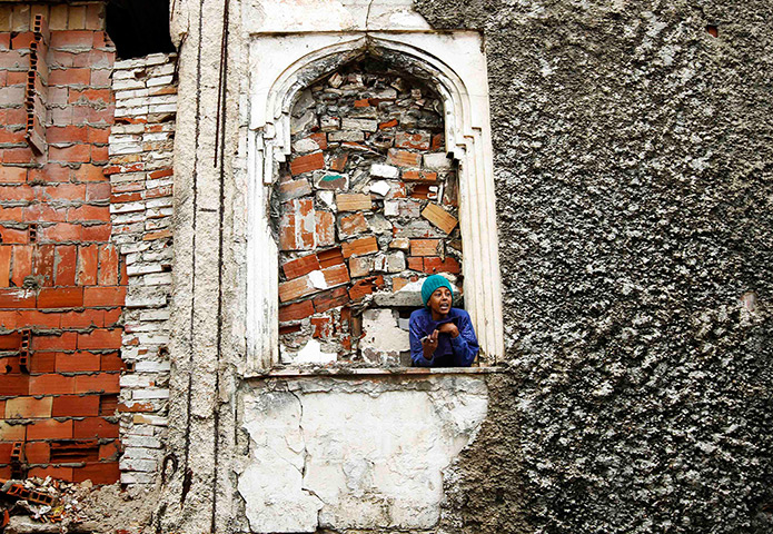 Somalia Goran Tomasevic: A woman looks out of a house destroyed during the war at a port, Mogadishu