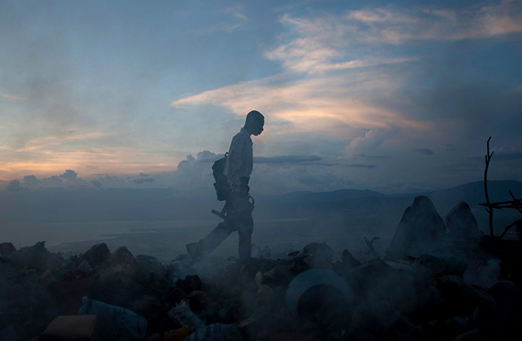 Picture desk live: A man searches for items on a rubbish dump in Petion-Ville, Haiti