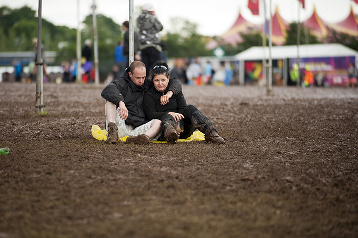 Wet festivals: Music fans sit in the mud and the rain during T In The Park Festival 