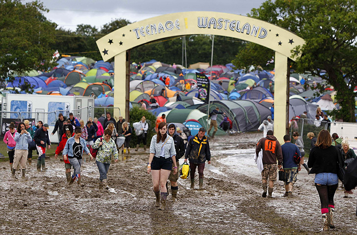 Wet festivals: Revellers walk through the muddy campsite at the Isle of Wight festival